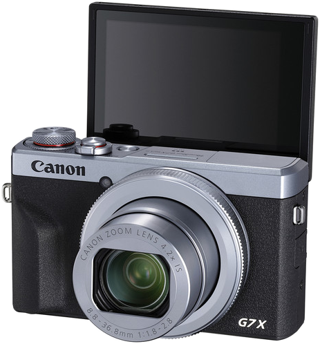 Canon G7X kamera, fekete és ezüst, a lencse ki van nyújtva, a képernyő nyitva van.