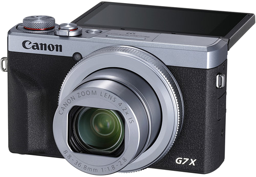 Fekete és ezüst kamera objektívvel. Az objektív ki van nyújtva. A márka Canon, a modell G7X.