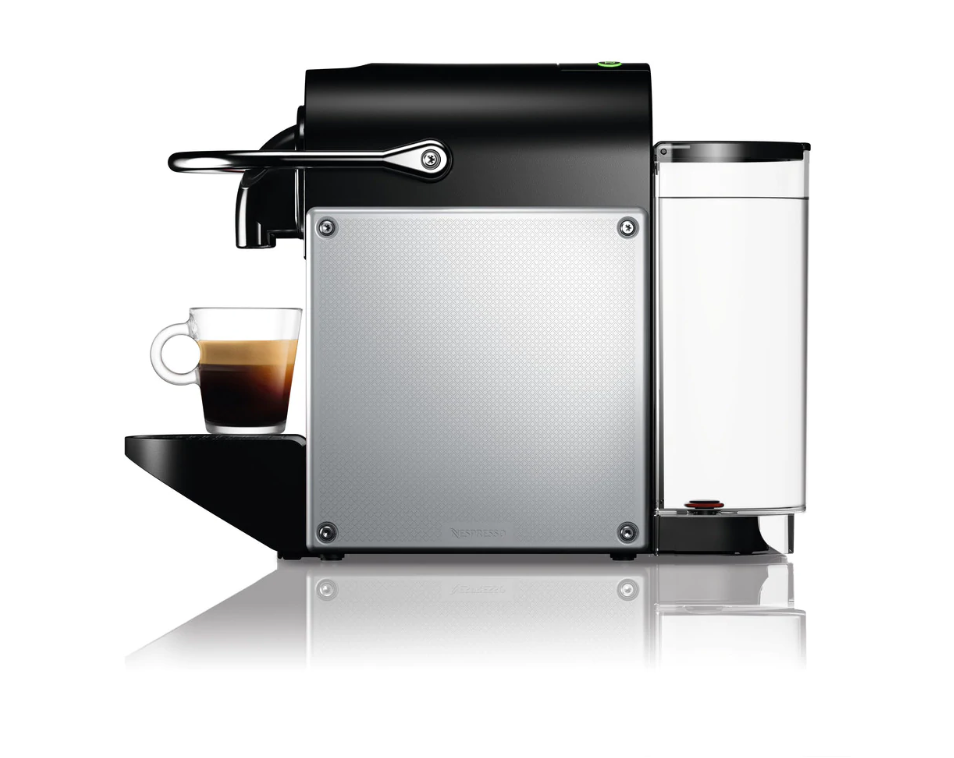 Eine schwarze Nespresso-Kaffeemaschine mit einer Tasse Espresso und einem Wassertank.