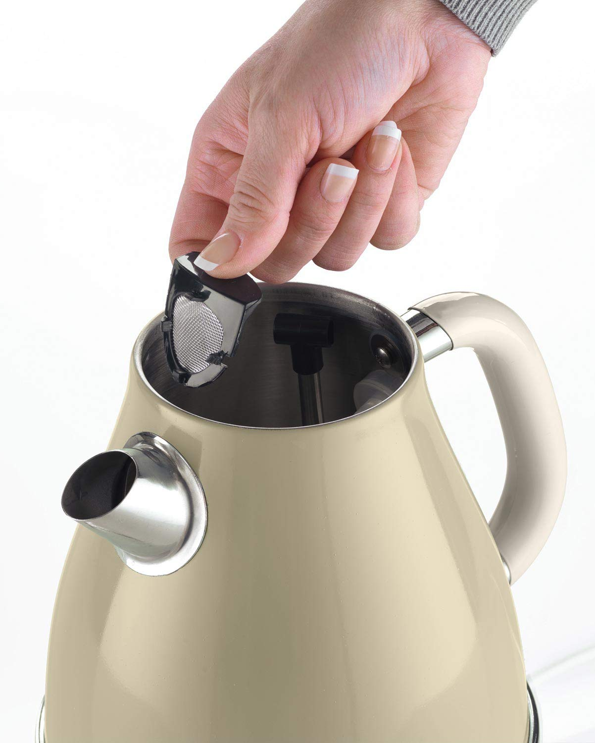 Eine Hand setzt einen Filter in einen beigefarbenen Wasserkocher mit silbernem Ausguss.