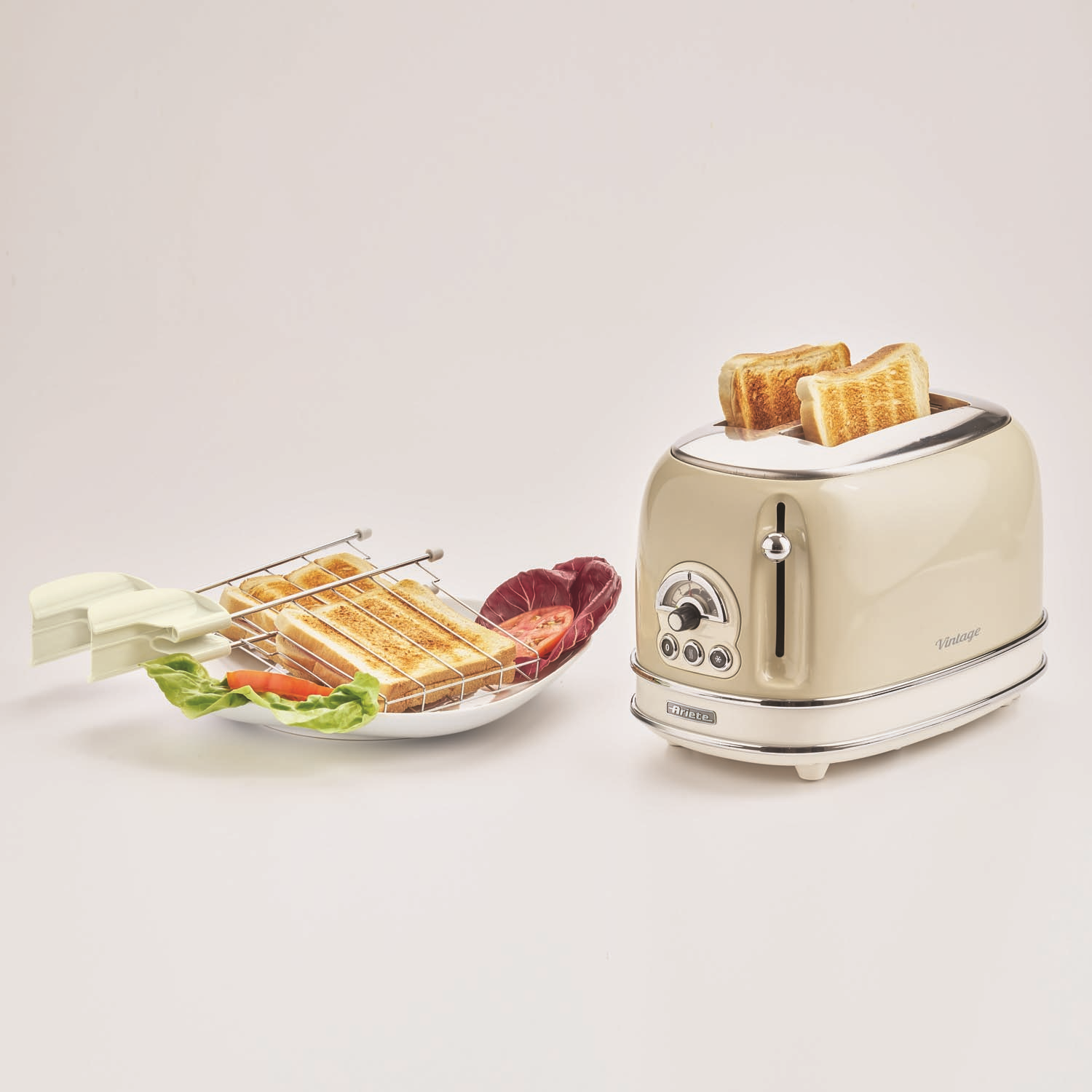 Beiger Toaster mit Toast und einem Teller mit Toast und Gemüse.