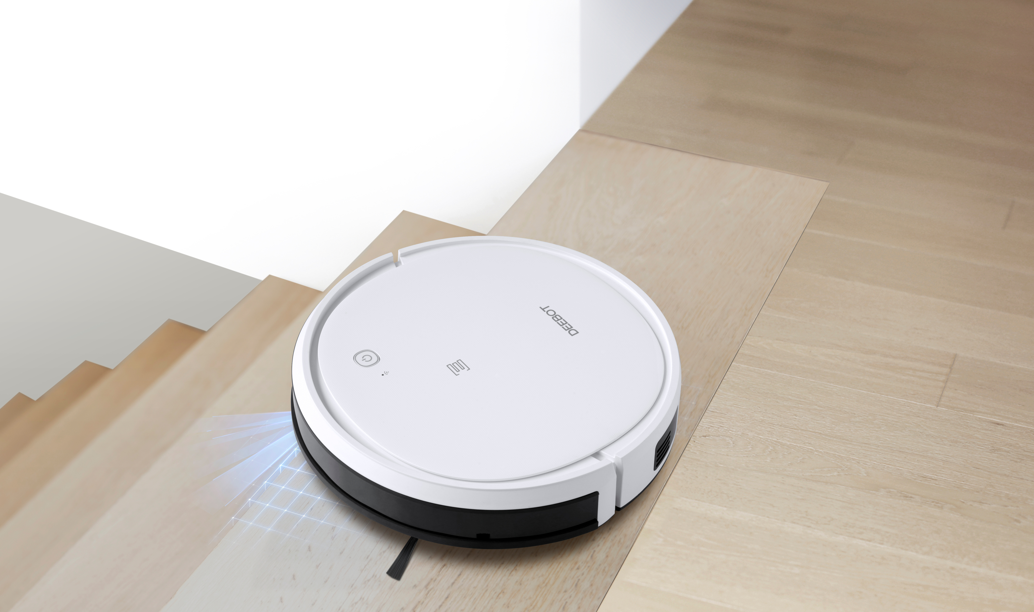 Roboter-Staubsauger in der Nähe einer Treppe. Es ist ein weißer Staubsauger auf einer Holztreppe.