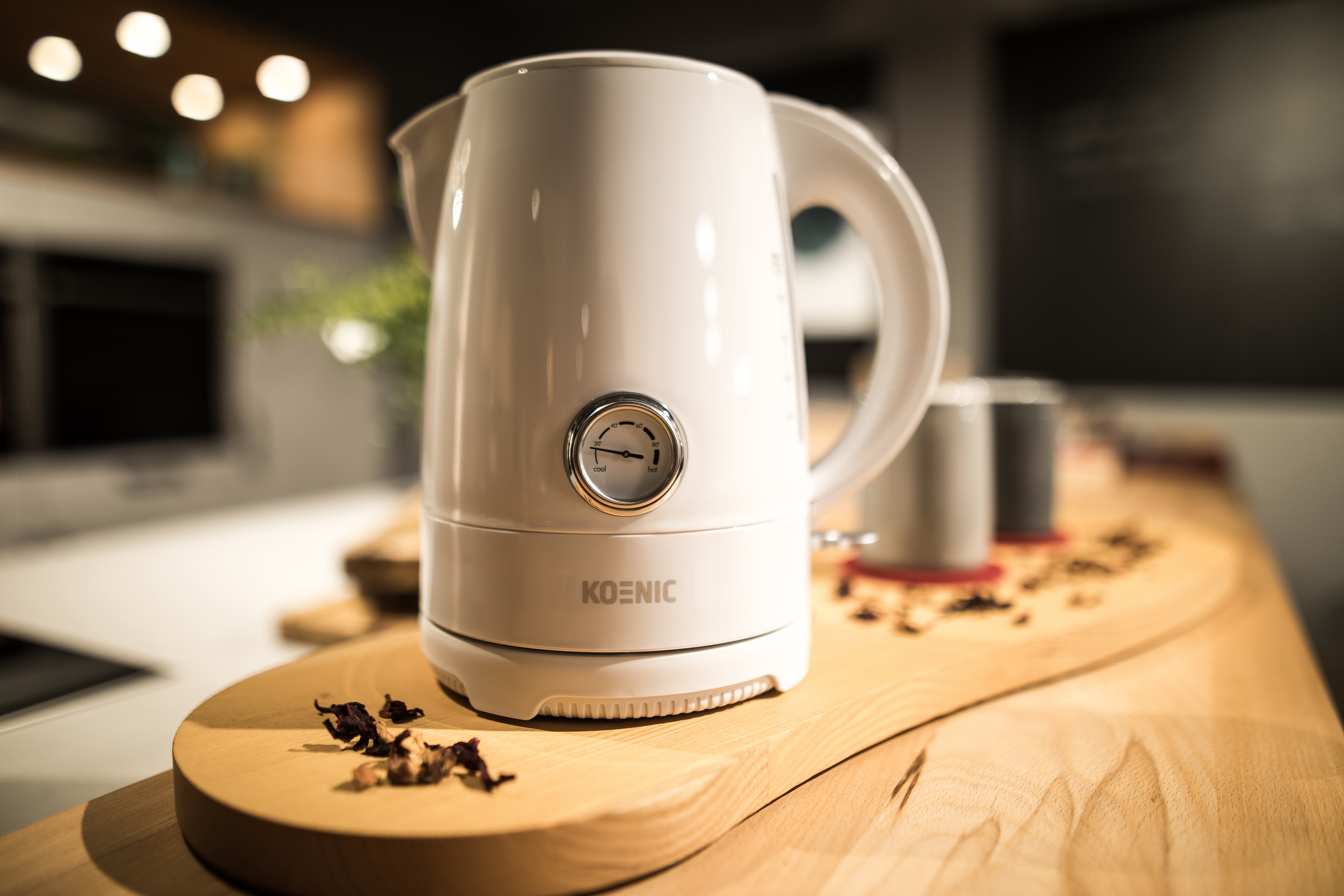 Weißer elektrischer Wasserkocher mit Temperaturanzeige auf einer Holzoberfläche.