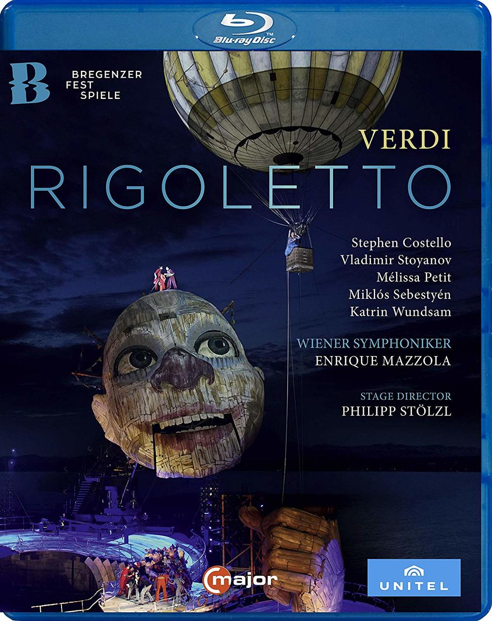 Blu-ray-Disc-Cover für die Oper 'Rigoletto', mit einem riesigen Kopf und einem Heißluftballon.