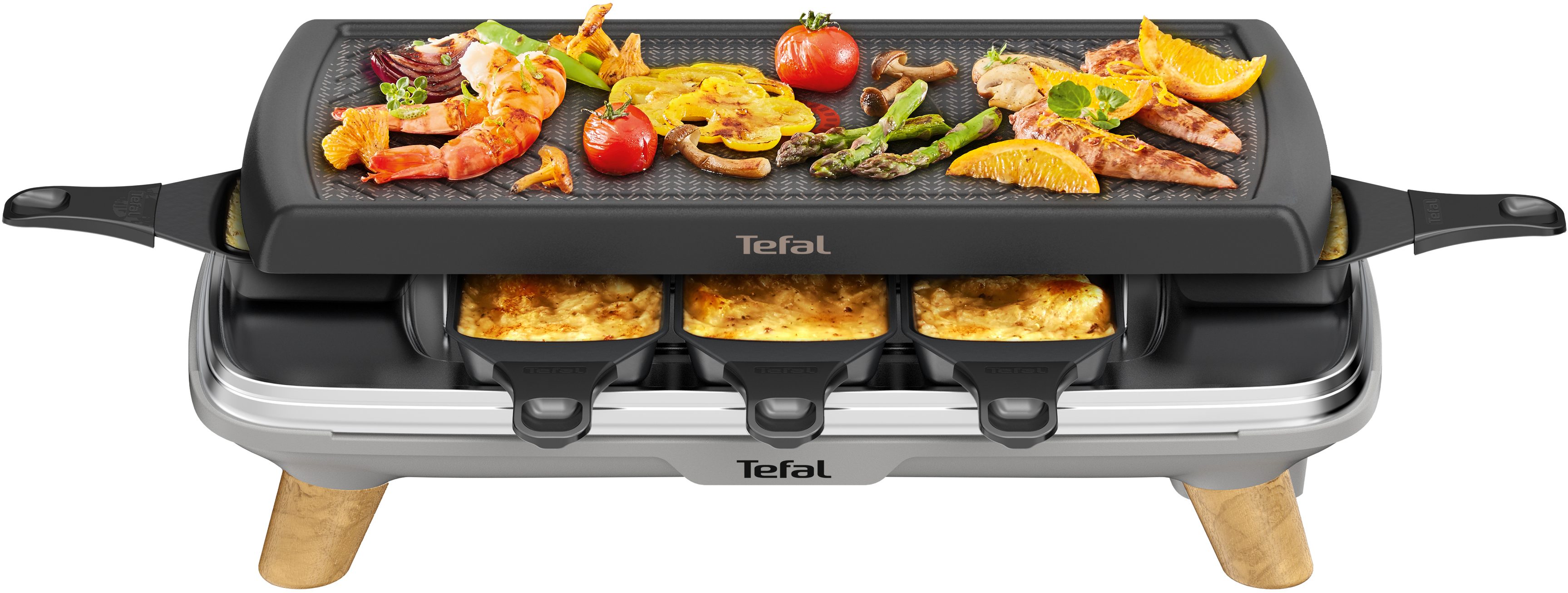 Tefal Raclette-Grill mit Essen: Garnelen, Tomaten, Spargel, Orangenscheiben. Käse in den Pfannen darunter.