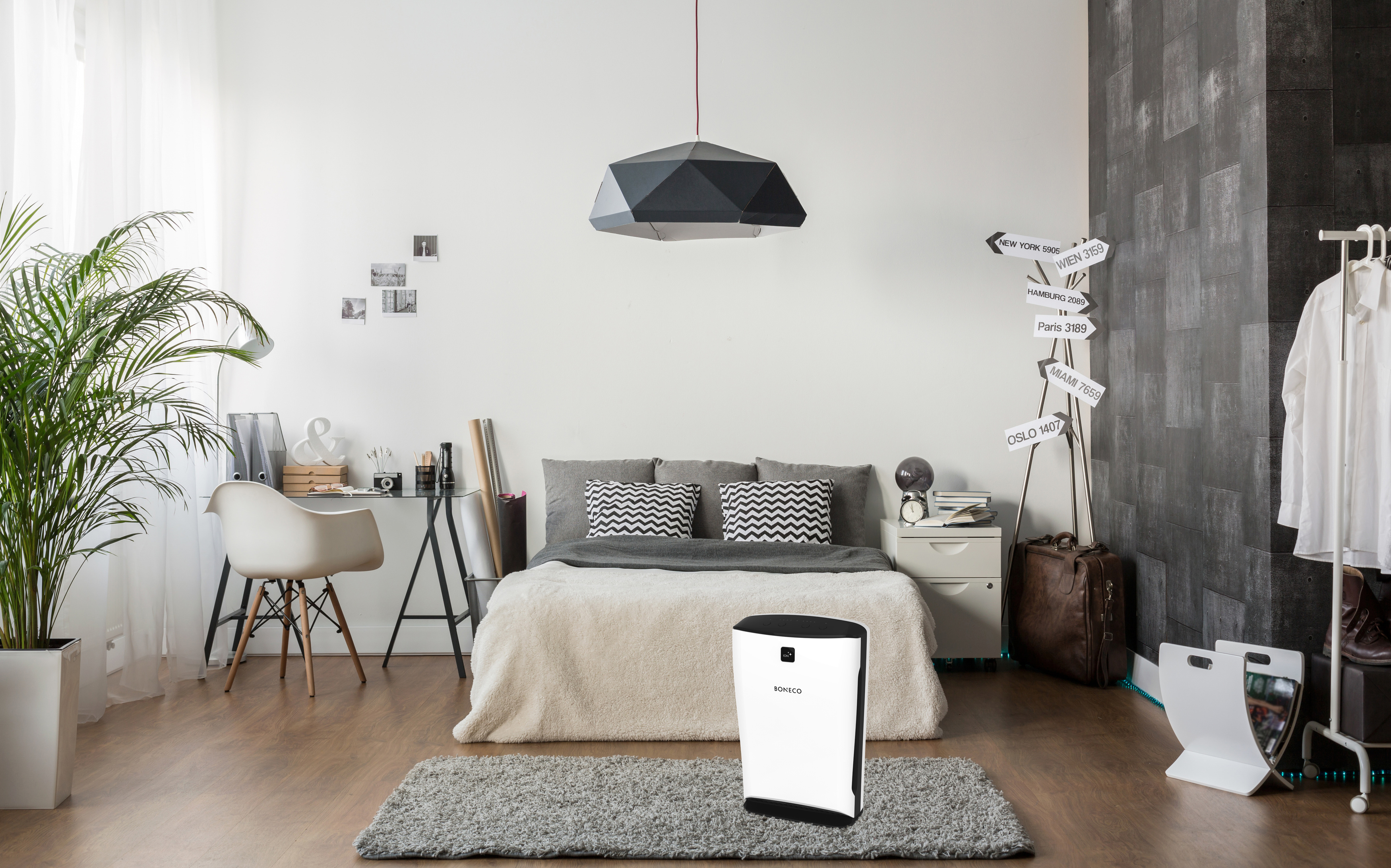 Schlafzimmer mit weißem Luftreiniger auf einem Teppich. Bett, Schreibtisch, Möbel.