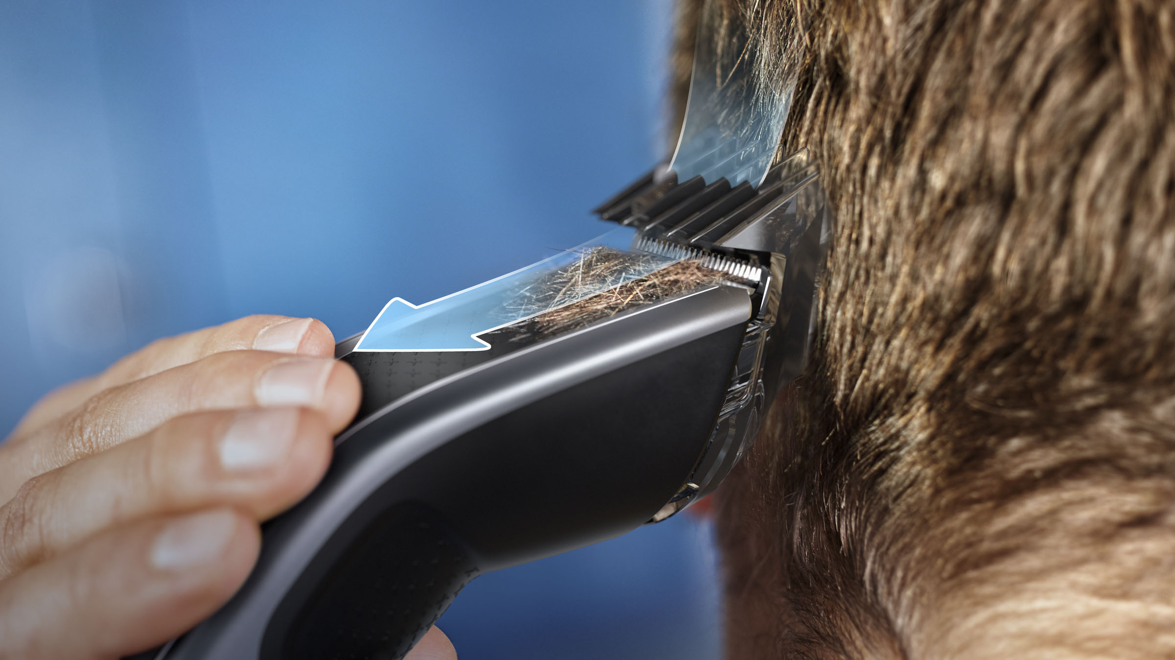 Jemandem werden die Haare mit einem Haarschneider geschnitten. Der Haarschneider ist schwarz und hat ein Fenster.