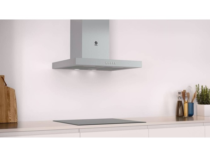 Escena de cocina moderna con campana extractora de acero inoxidable sobre vitrocerámica negra. Blanco.