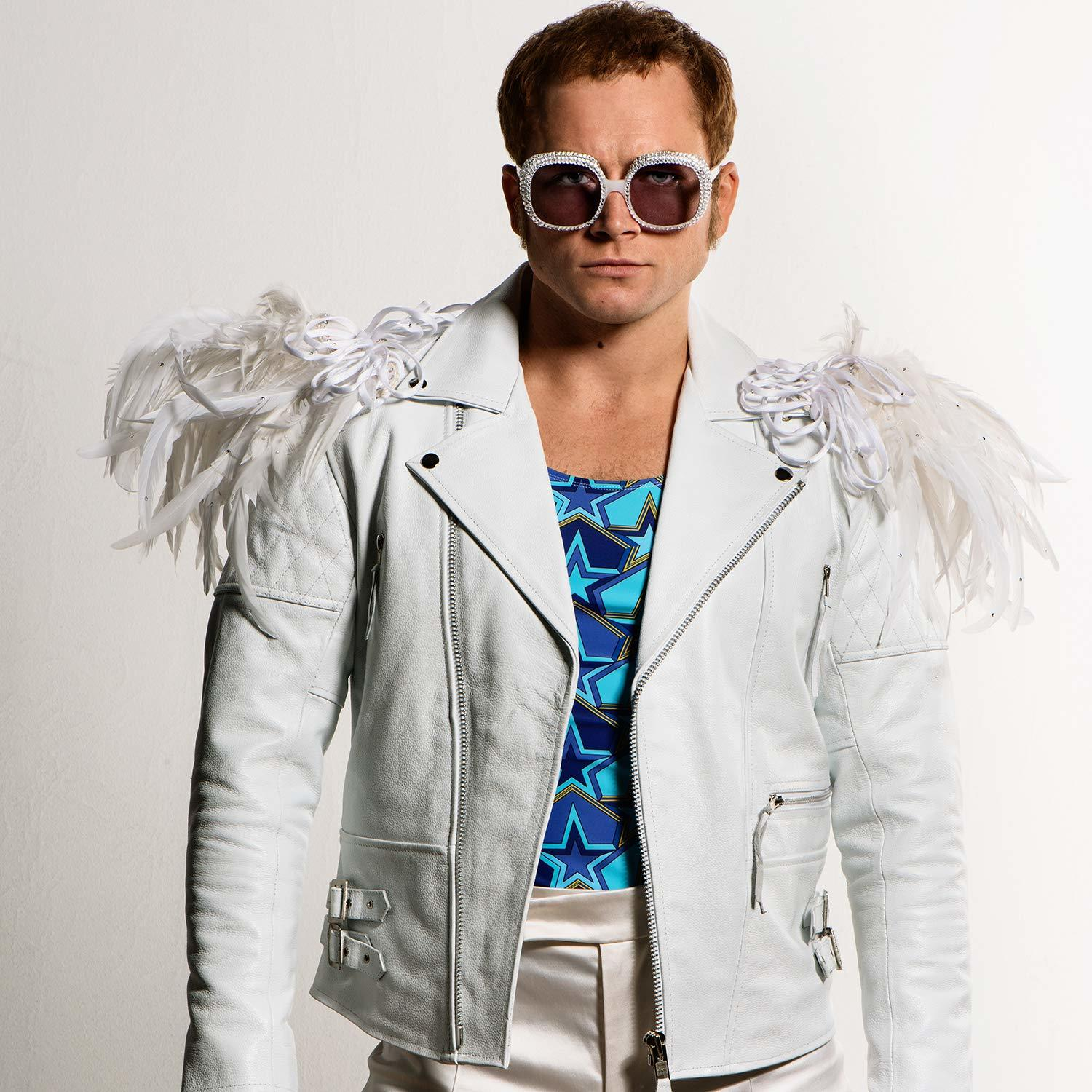 Elton John mit weißer Brille, Feder-Schultern und weißer Jacke.