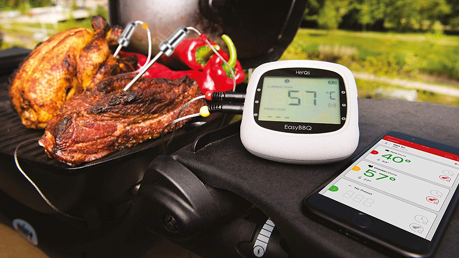 A grill thermometer shows 57°C next to meat and chicken on a grill.