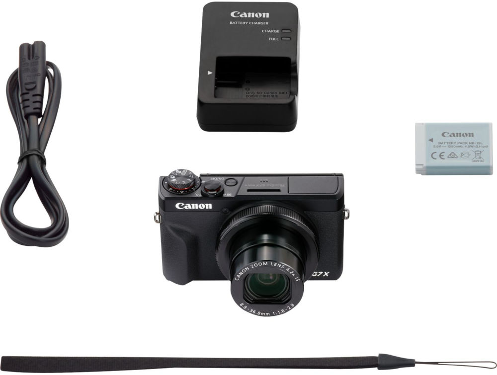 Camera and accessories: charger, battery, strap, and power cable.