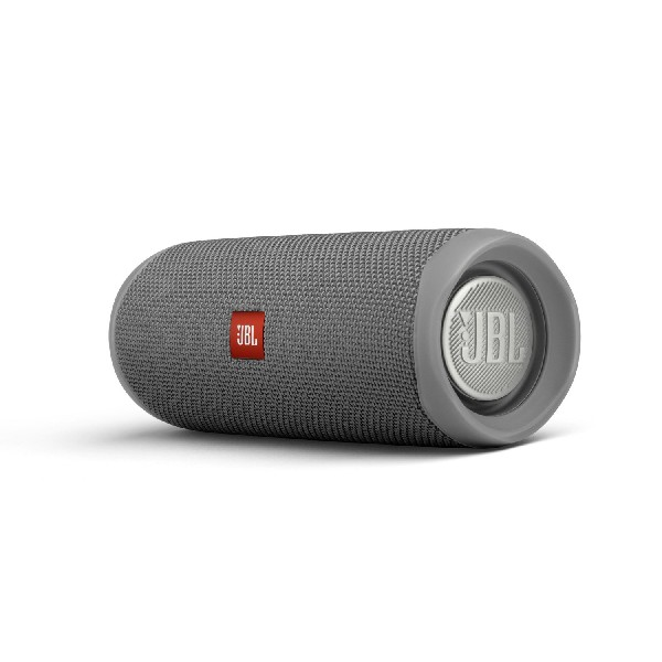 Un altavoz JBL gris, de forma cilíndrica, con el logotipo rojo de JBL visible.