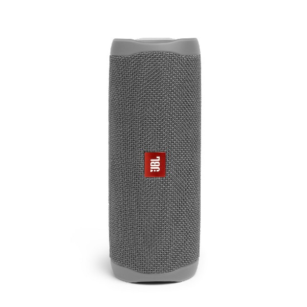 Altavoz JBL gris sobre un fondo blanco. Es cilíndrico y tiene un logotipo rojo de JBL.