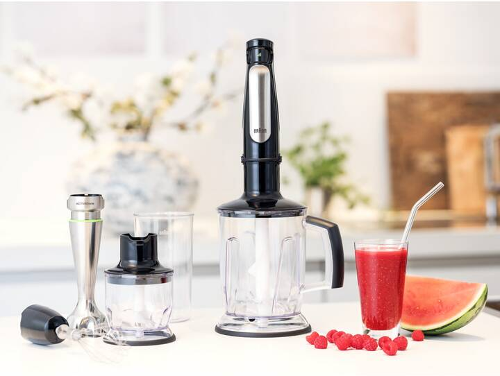 Stabmixer mit Aufsätzen, ein Glas und ein Glas roter Smoothie, Himbeeren und Wassermelone.