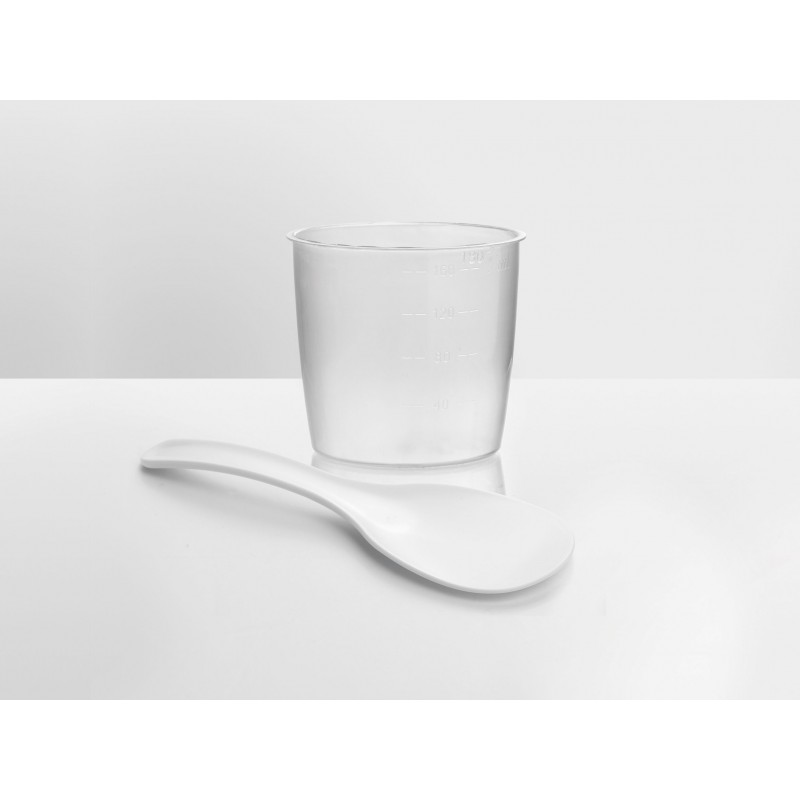 Clear plastic measuring cup and white spoon on white surface.