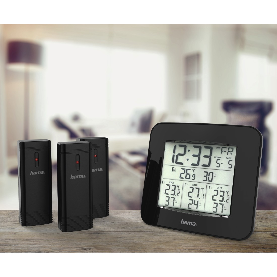 Black weather station with display showing time, date, and temperature. Three black sensors are on the left.