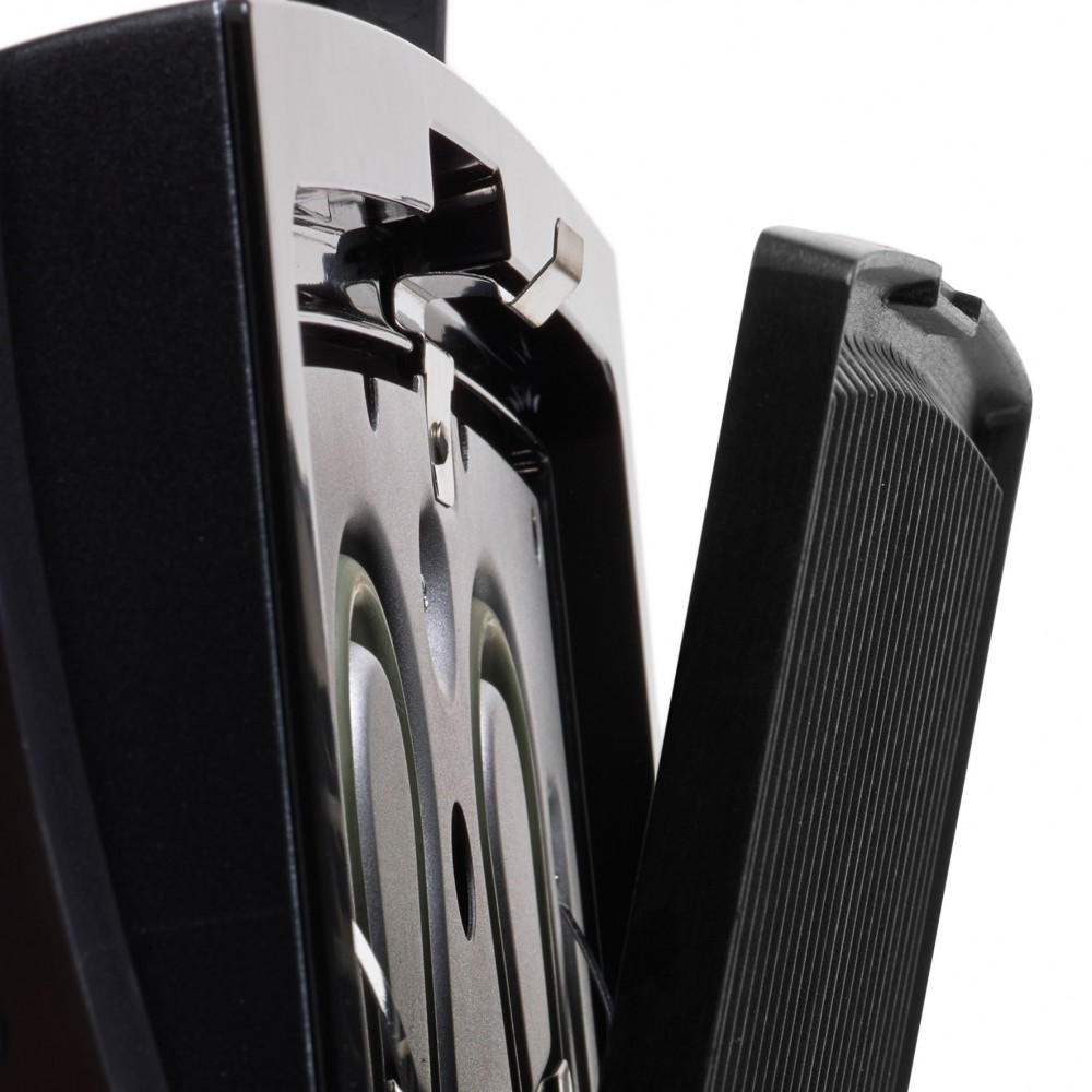 Close-up of a black pedal, with a metal hinge and a textured surface.