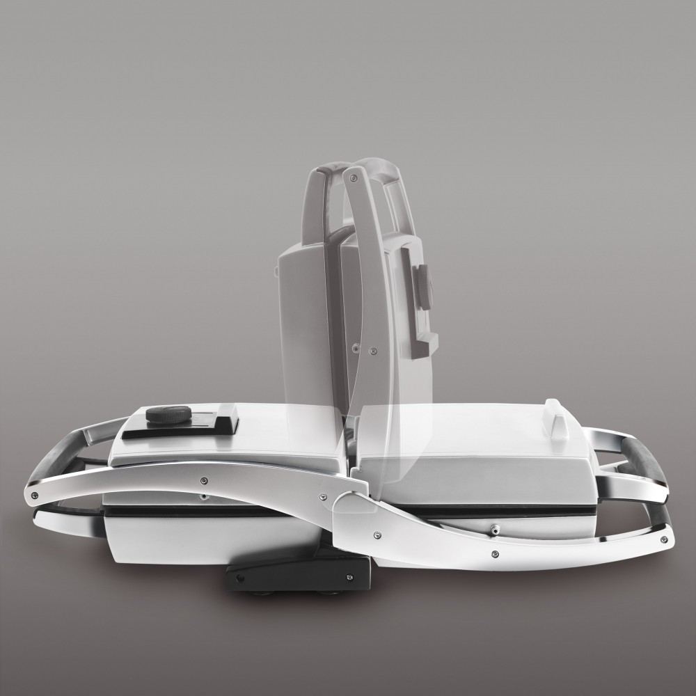 A waffle iron in an open position, grey background.