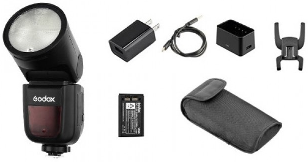 Un flash d'appareil photo noir avec accessoires : chargeur, câble, récepteur, batterie et étui. Fond blanc.