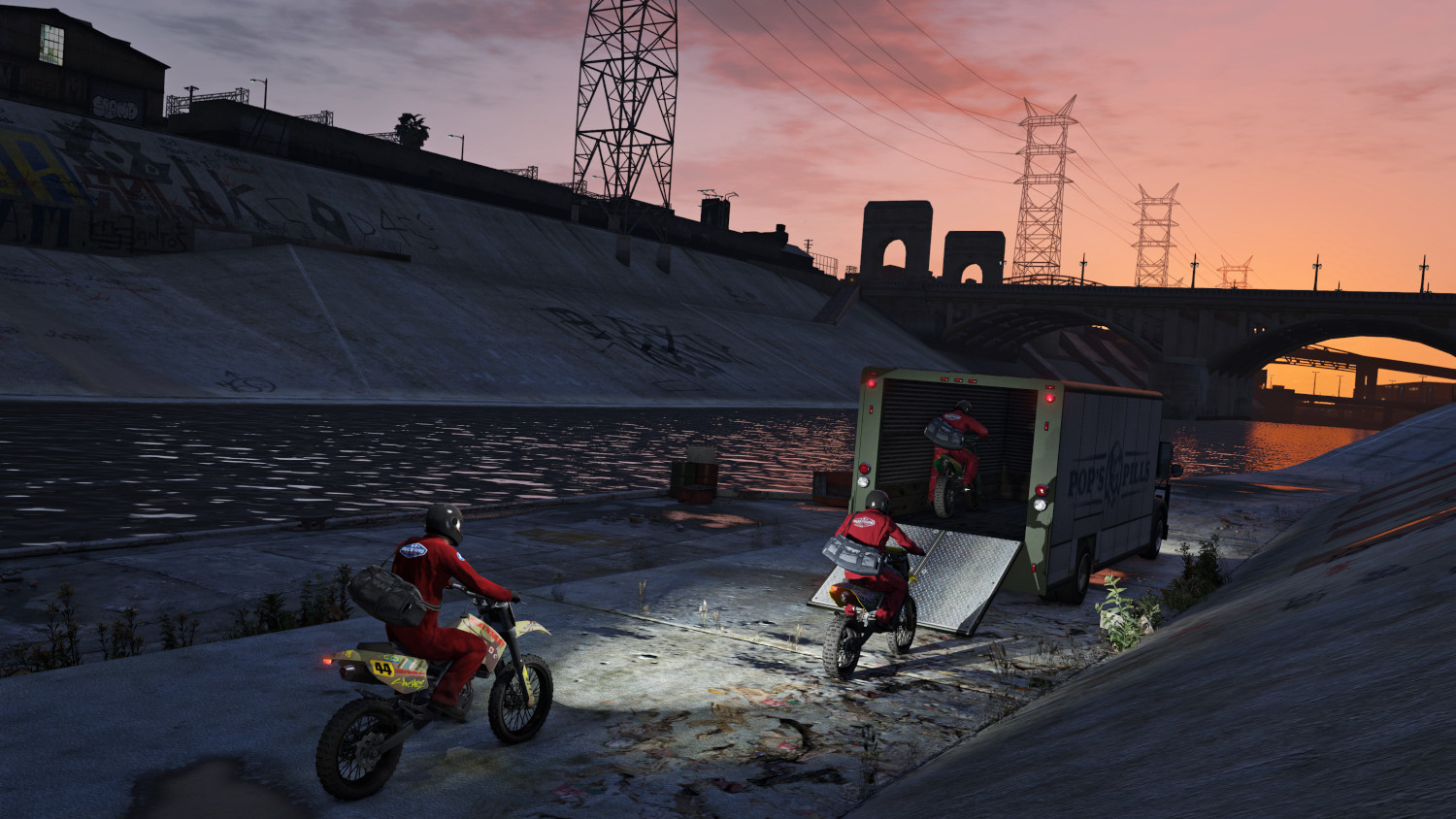 Motocyclistes sortant d'un camion près d'une rivière. Fond de coucher de soleil.