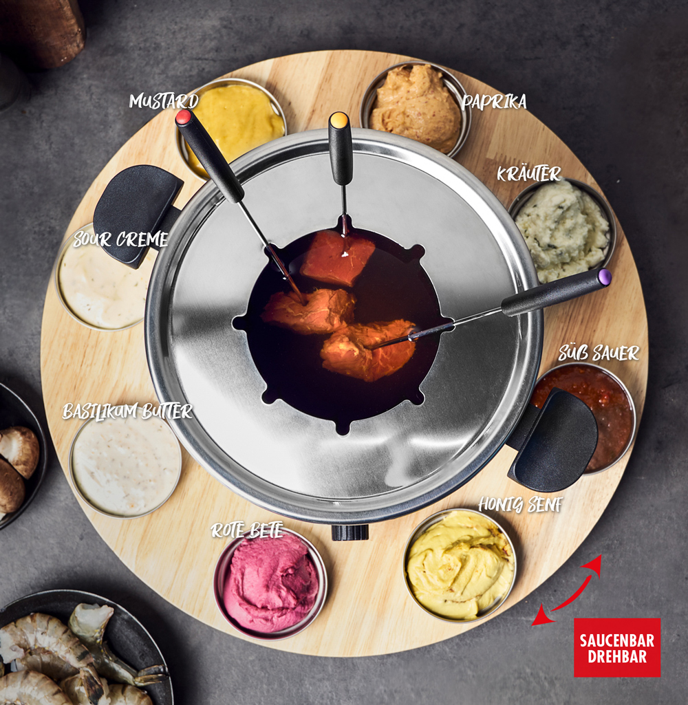 Ein Fondue-Set. Es gibt mehrere Schalen mit Soßen und Zutaten um einen Topf mit geschmolzenem Essen.