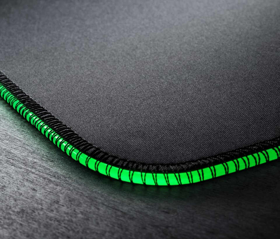 Tapis de souris noir avec bordure verte. Le bord est cousu avec du fil vert vif, visible sur la surface.