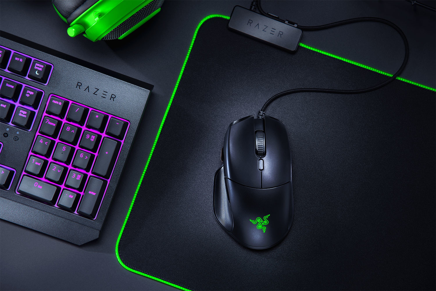 Ratón y teclado gaming Razer negros con detalles verdes y una alfombrilla verde. El conjunto está en un escritorio.