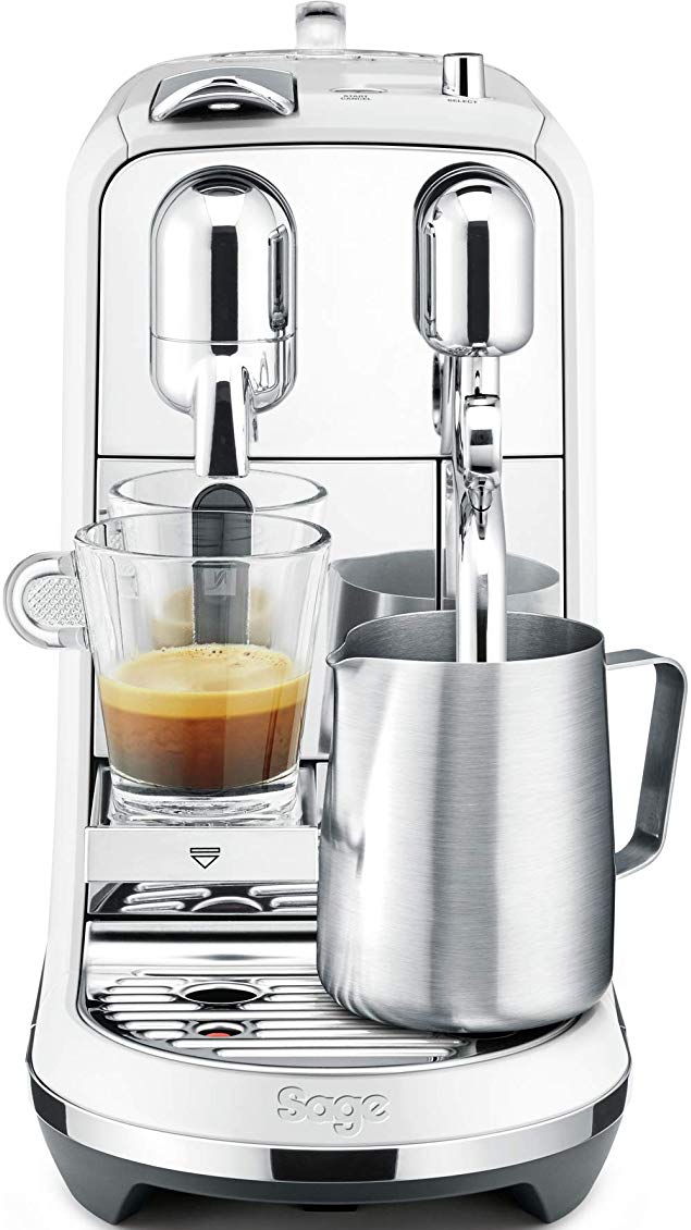 Macchina per espresso bianca con una tazza di vetro, un bricco per montare il latte e due beccucci.