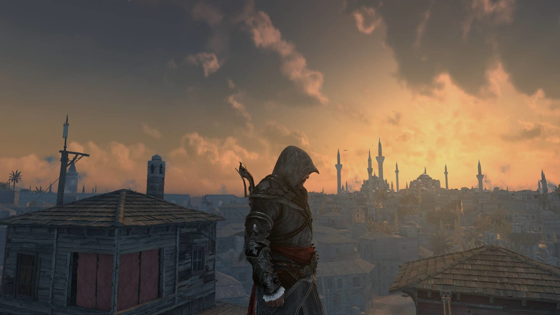 Une personne encapuchonnée debout sur un toit, surplombant une ville au coucher du soleil.