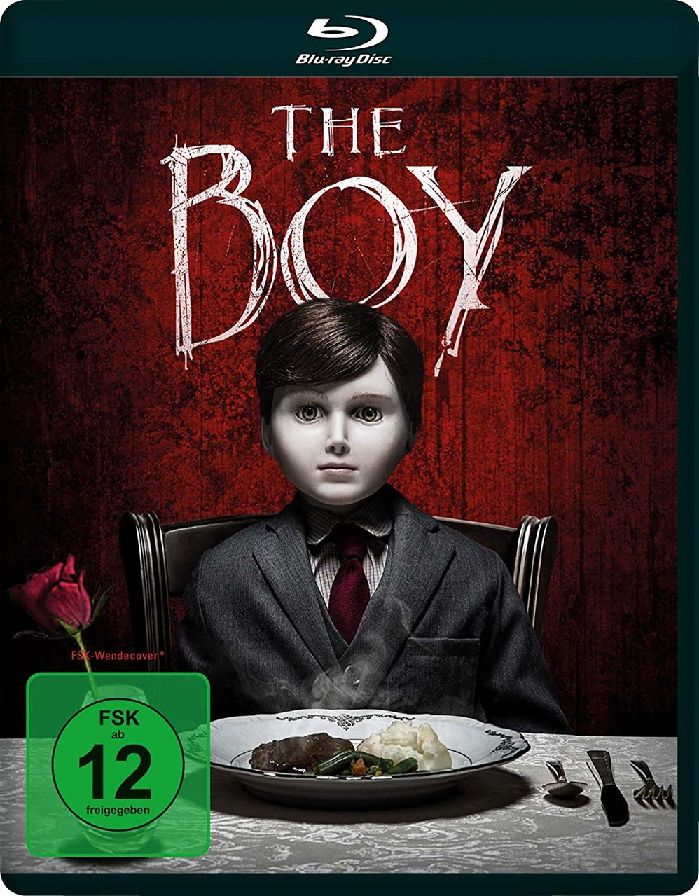 Das Boy Blu-ray-Cover. Eine Puppe sitzt an einem Tisch. Eine Rose und ein Teller mit Essen sind sichtbar.