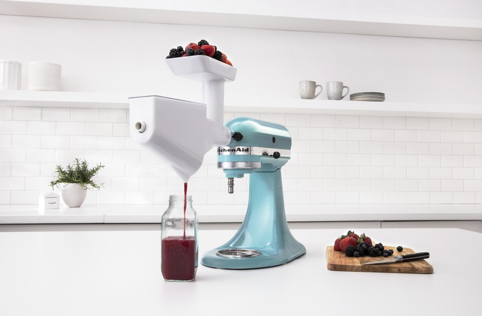 Ein blauer KitchenAid-Küchenmixer mit Fruchtsaftpressen-Aufsatz.