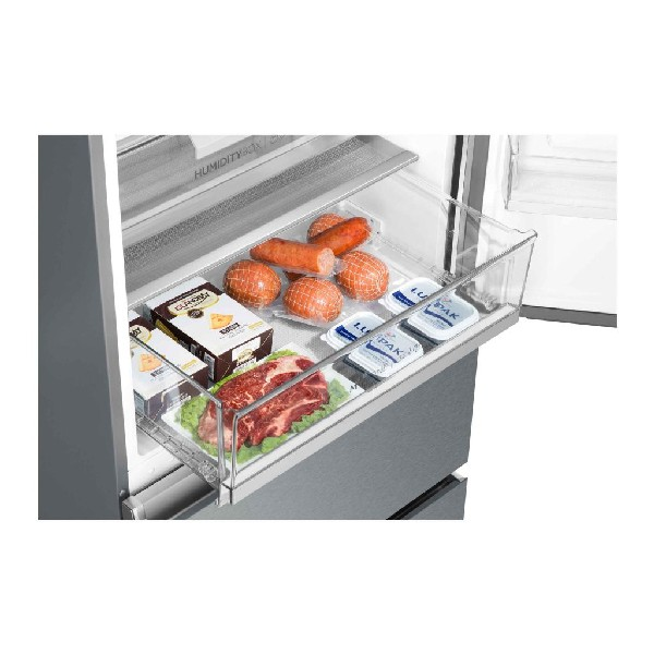 Cajón del refrigerador con varias carnes, queso y productos lácteos. Contenedor transparente con alimentos frescos.