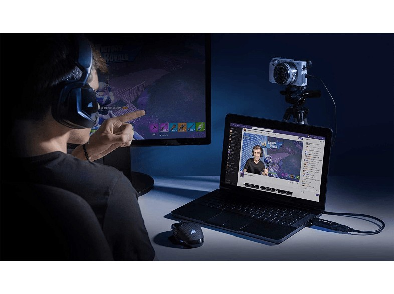 Una persona con auriculares señala un monitor. Hay una cámara configurada.