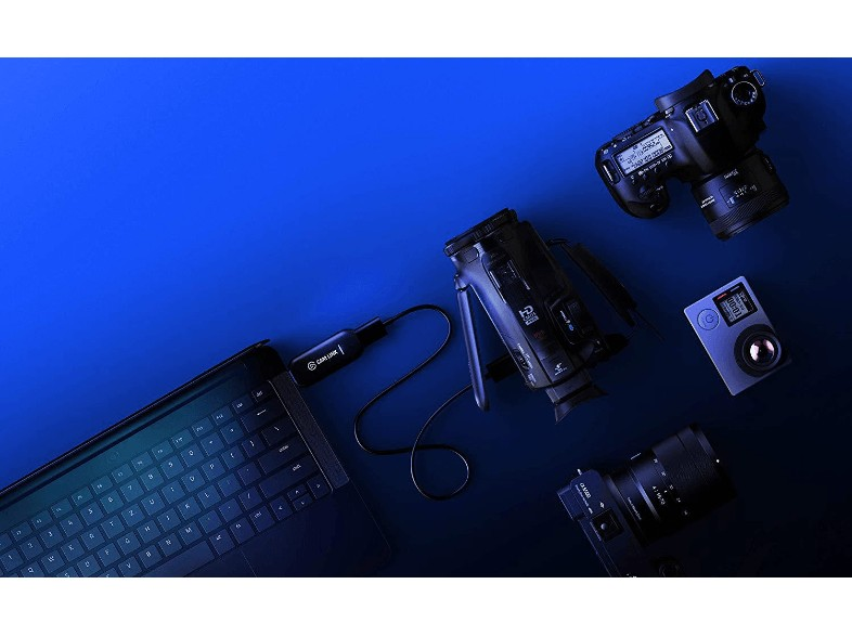 Laptop, cámaras y una videocámara sobre una superficie azul, conectados por un cable negro.