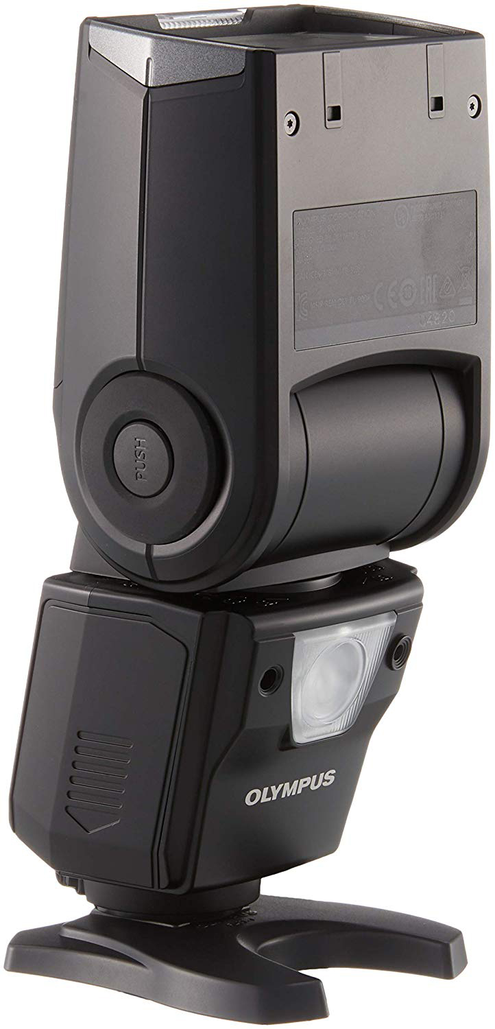 Een zwarte Olympus flitser. Hij is omhoog gekanteld met een lamp aan.