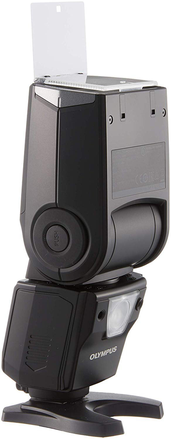 Zwarte Olympus-flitser met een witte diffuser, gemonteerd op een zwarte basis. Vooraanzicht.