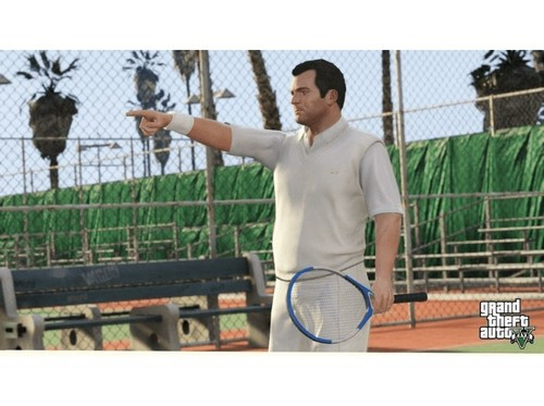 Un hombre con camisa blanca señala hacia un lado en una cancha de tenis. Una valla de alambre está al fondo.
