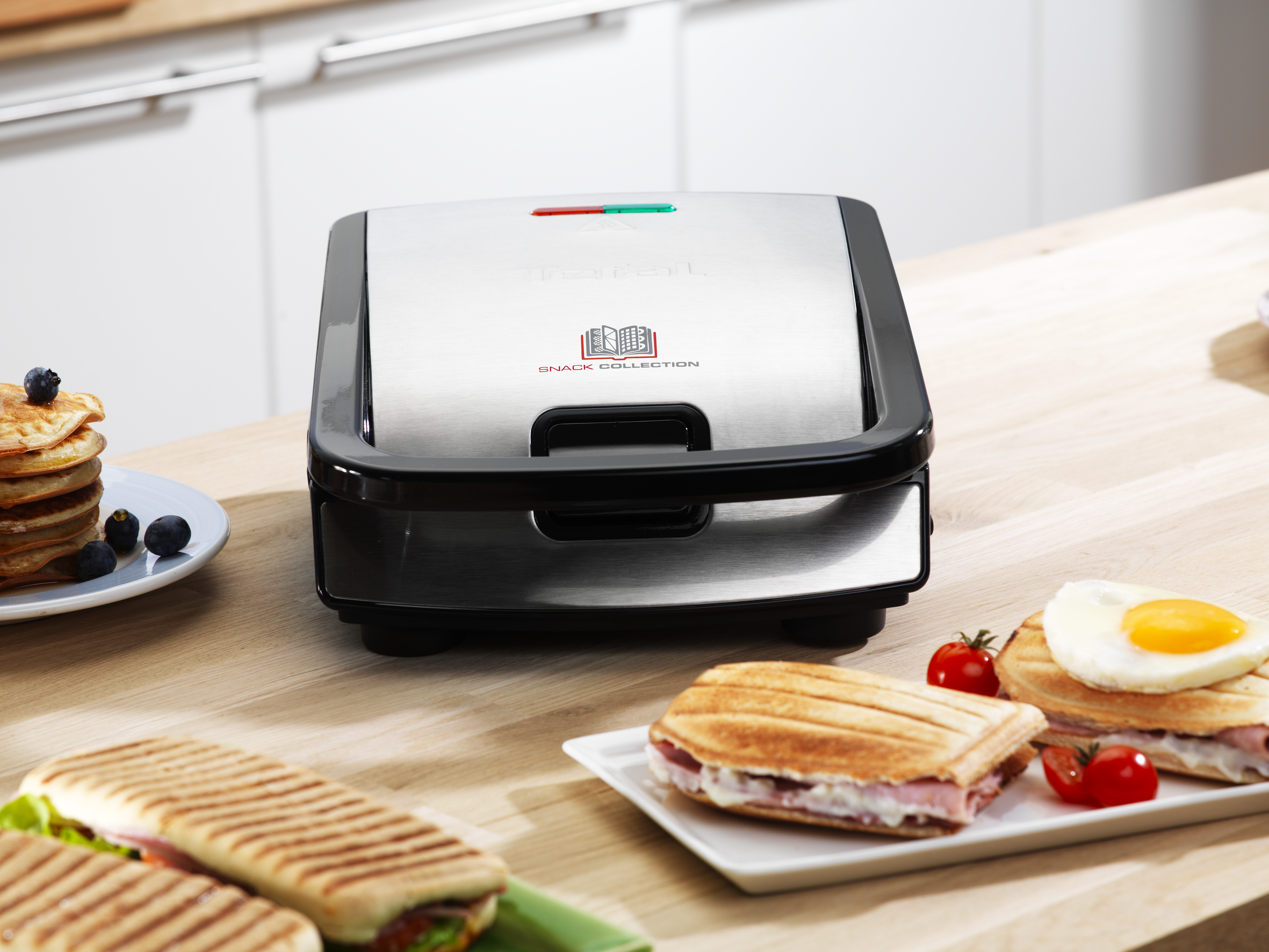 Tefal snackmaker, met sandwiches en pannenkoeken. Achtergrond: keuken.