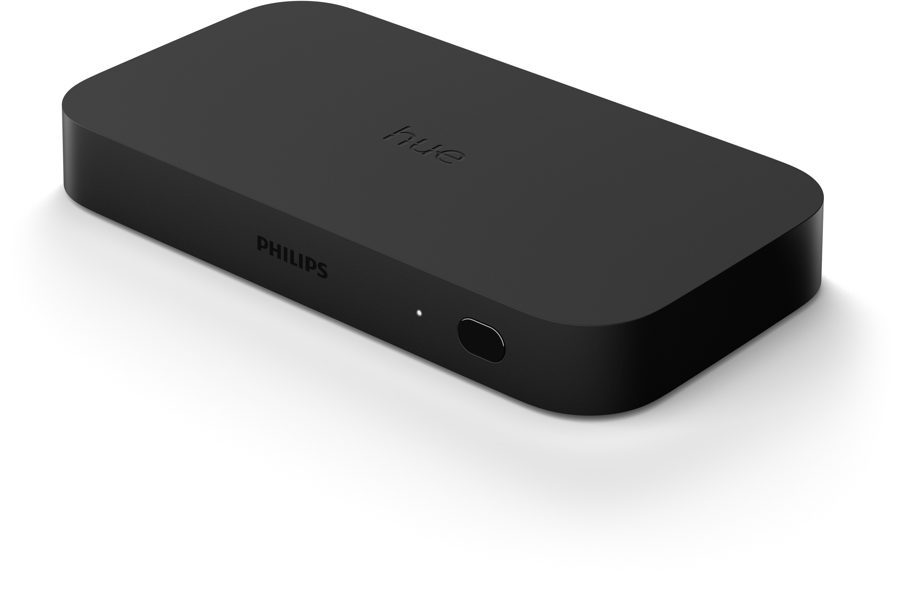 Ein schwarzes Philips Hue Bridge-Gerät auf weißer Oberfläche.