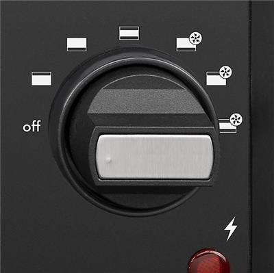 Gros plan sur un cadran de commande de four noir avec des marquages et une lumière rouge.
