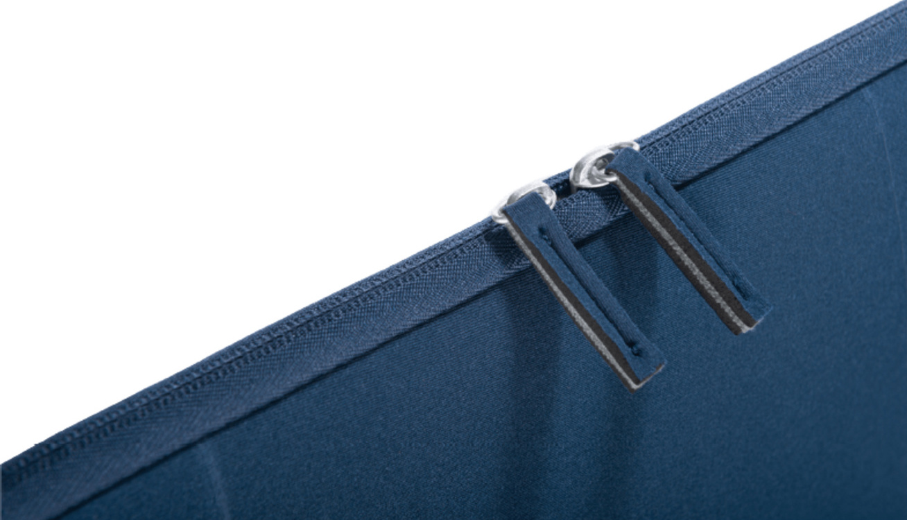 Close-up van een blauwe stof met twee metalen ritsen. De ritsen hebben grijze pullers.