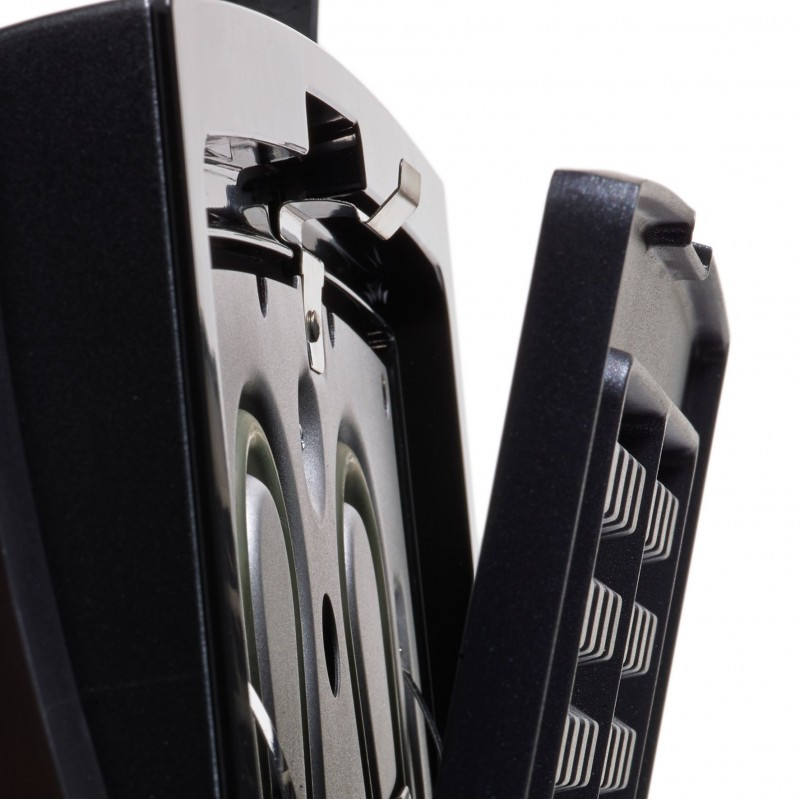 Close-up of a black appliance with a metal interior. A latch is visible, and a vent is on the right.