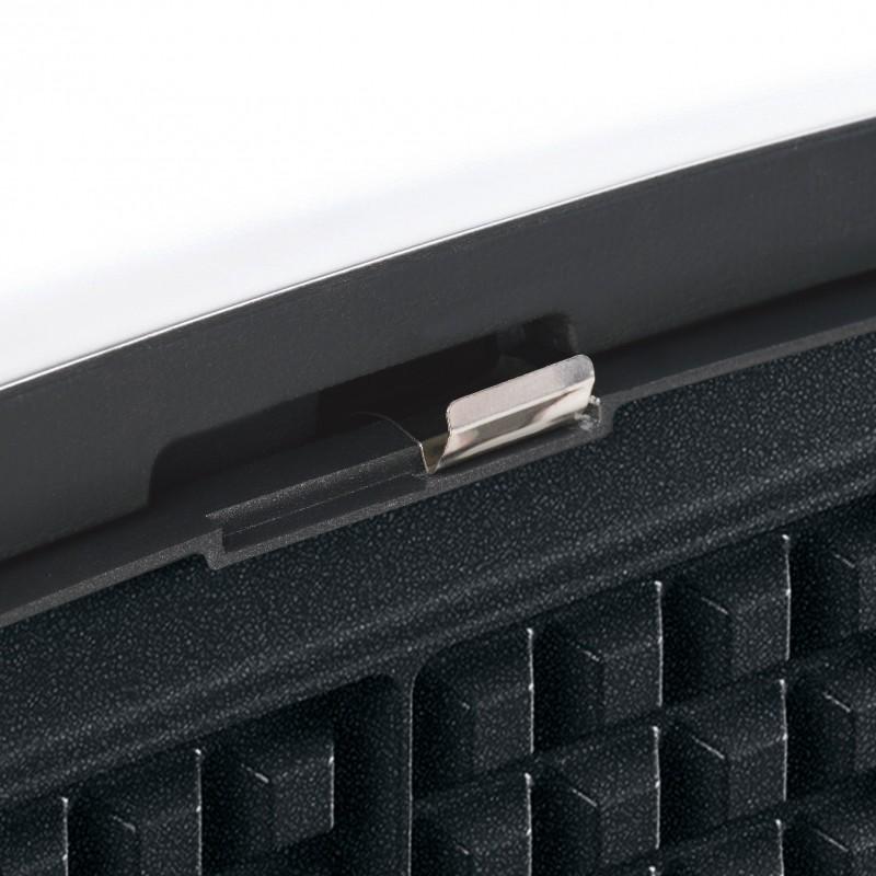 Close-up of a small metal clip attached to a dark, textured surface with a black outline.