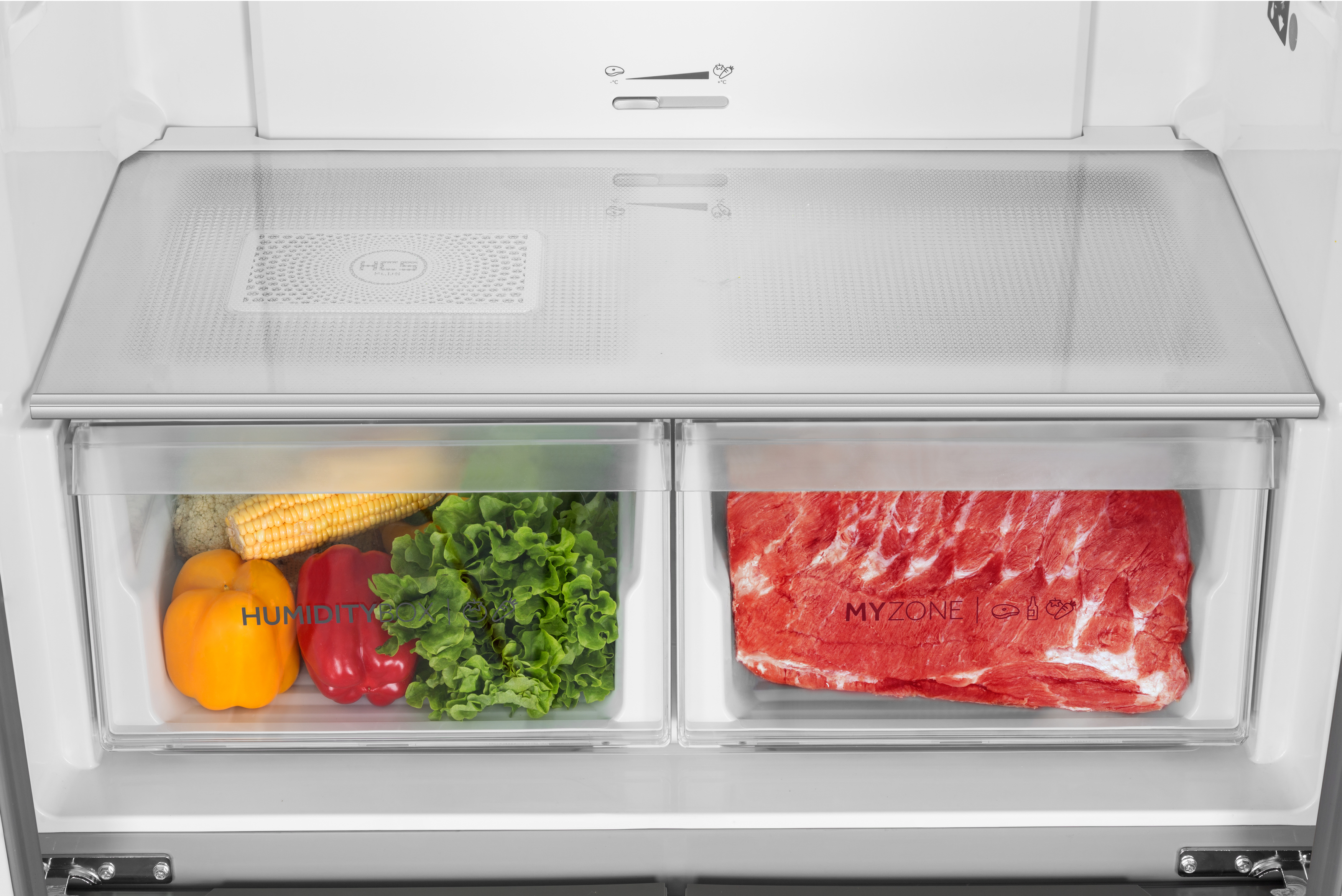 Kühlschrankinnenraum mit Schubladen, Gemüse und Fleisch. Transparente Kunststoffbehälter.