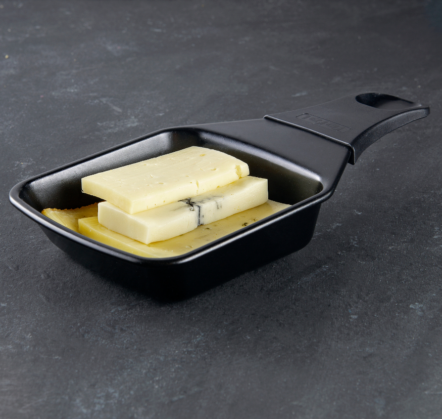 Black raclette grill pan with cheeses.