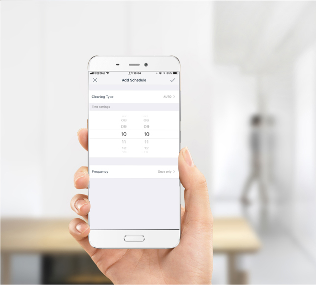 Eine Hand, die ein Telefon hält, auf dem eine Reinigungsplan-App angezeigt wird. Weißer Hintergrund.