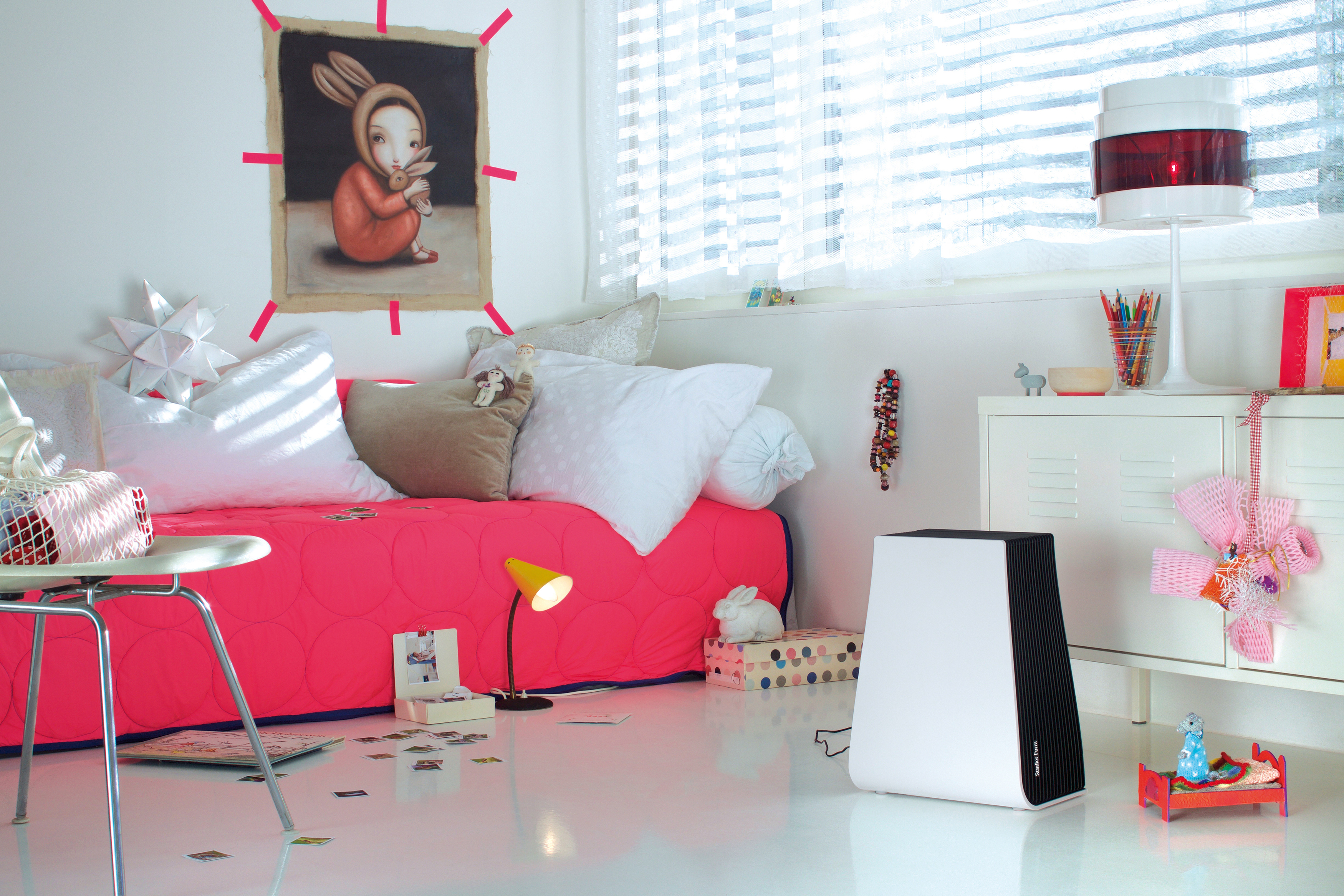 Kinderzimmer mit rotem Bett und Hasenbild. Ein weißer Luftreiniger ist vorhanden.