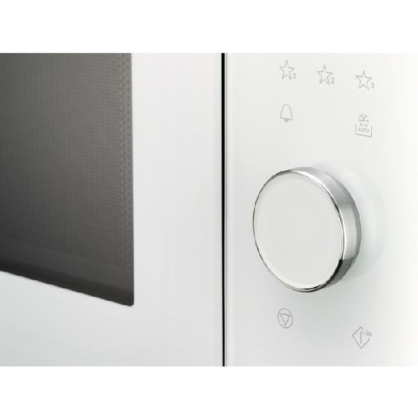 Primer plano de un microondas blanco. Se ve un panel de control con botones y un dial. La puerta está a la izquierda.
