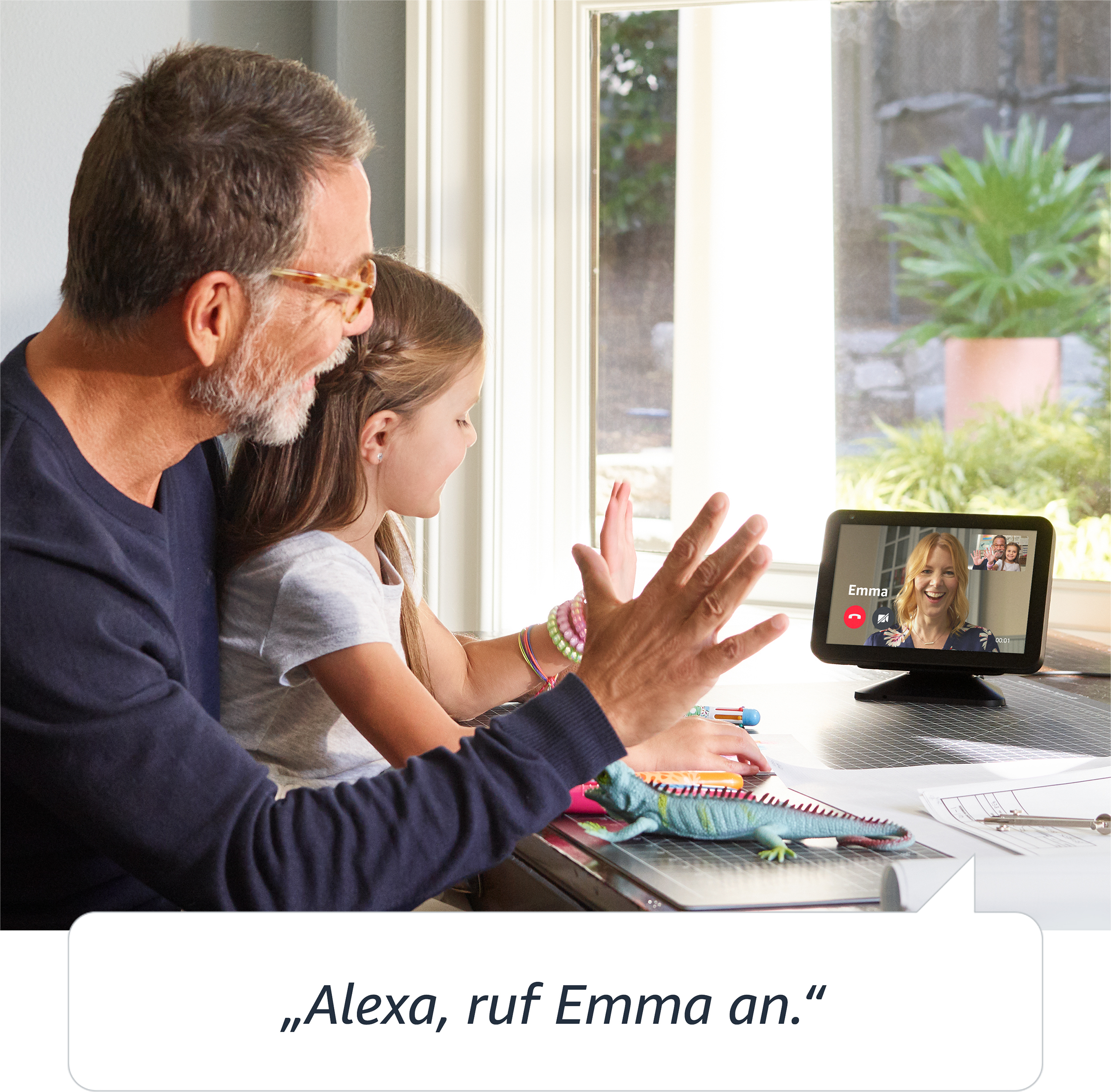 Ein Vater und eine Tochter telefonieren per Video, mit Text: Alexa, rufe Emma an.