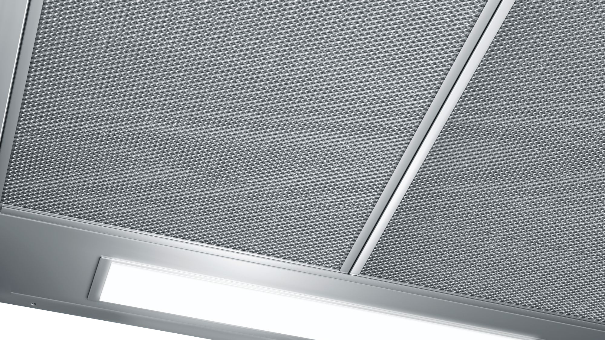 Gros plan d'une hotte aspirante en acier inoxydable avec grille et panneau lumineux.